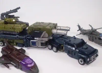 Collection of toy military vehicles including tanks, trucks, a helicopter, and a missile launcher.