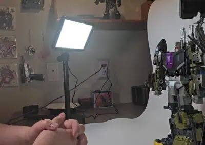 Robotic figure being photographed with professional lighting and background.