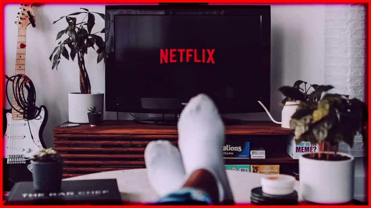 Person watching Netflix on TV with feet up in a cozy living room.