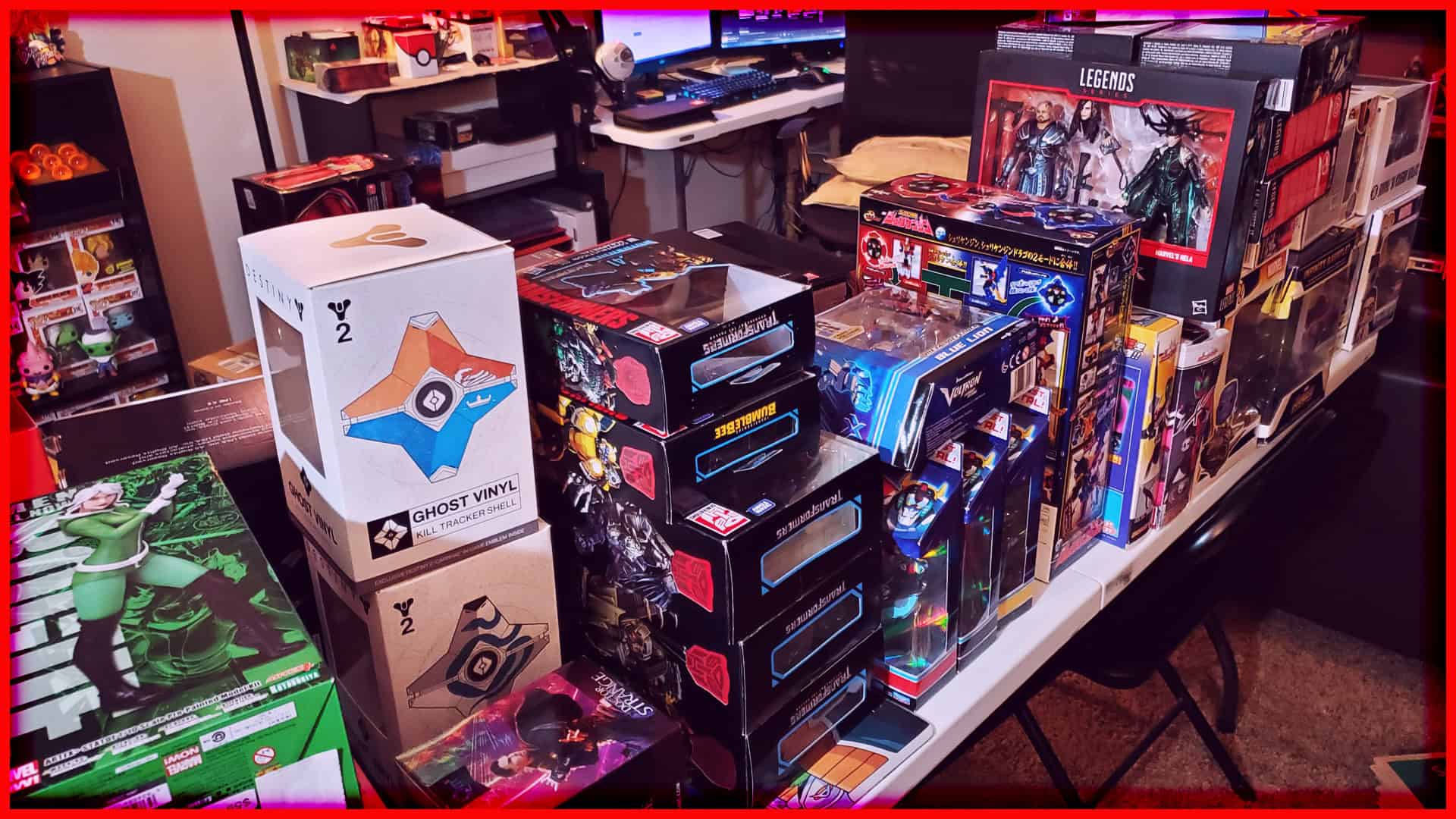 Collection of boxed action figures and collectibles on a cluttered desk.
