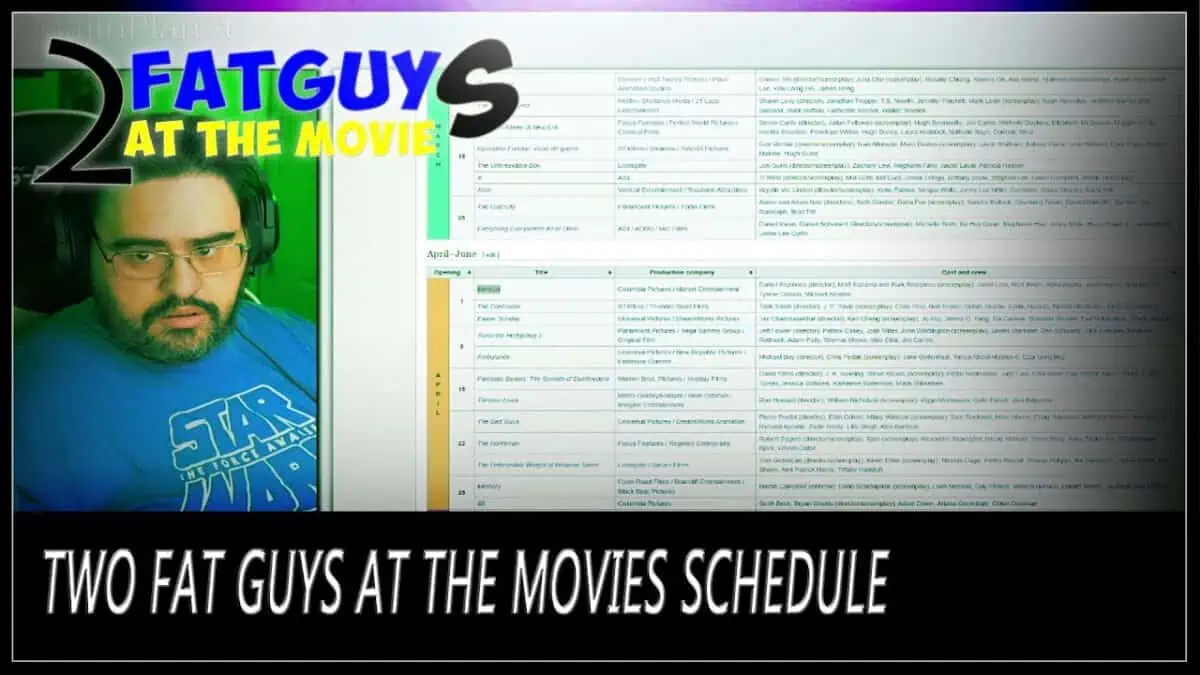 Two fat guys at the movies schedule with a man in a blue Star Wars shirt and headphones.