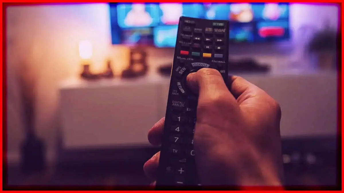Remote control for television with colorful display in a cozy living room setting.