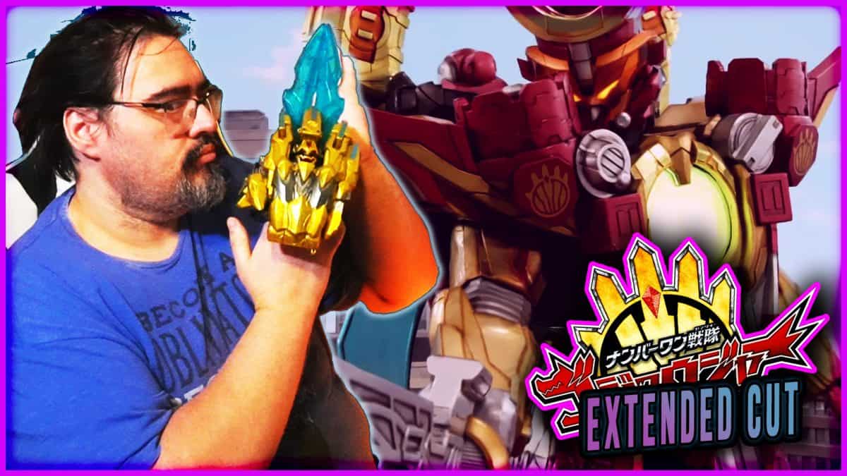 Man holding a blue and gold Majin Planet Gozyuger figure with a giant robot in background.